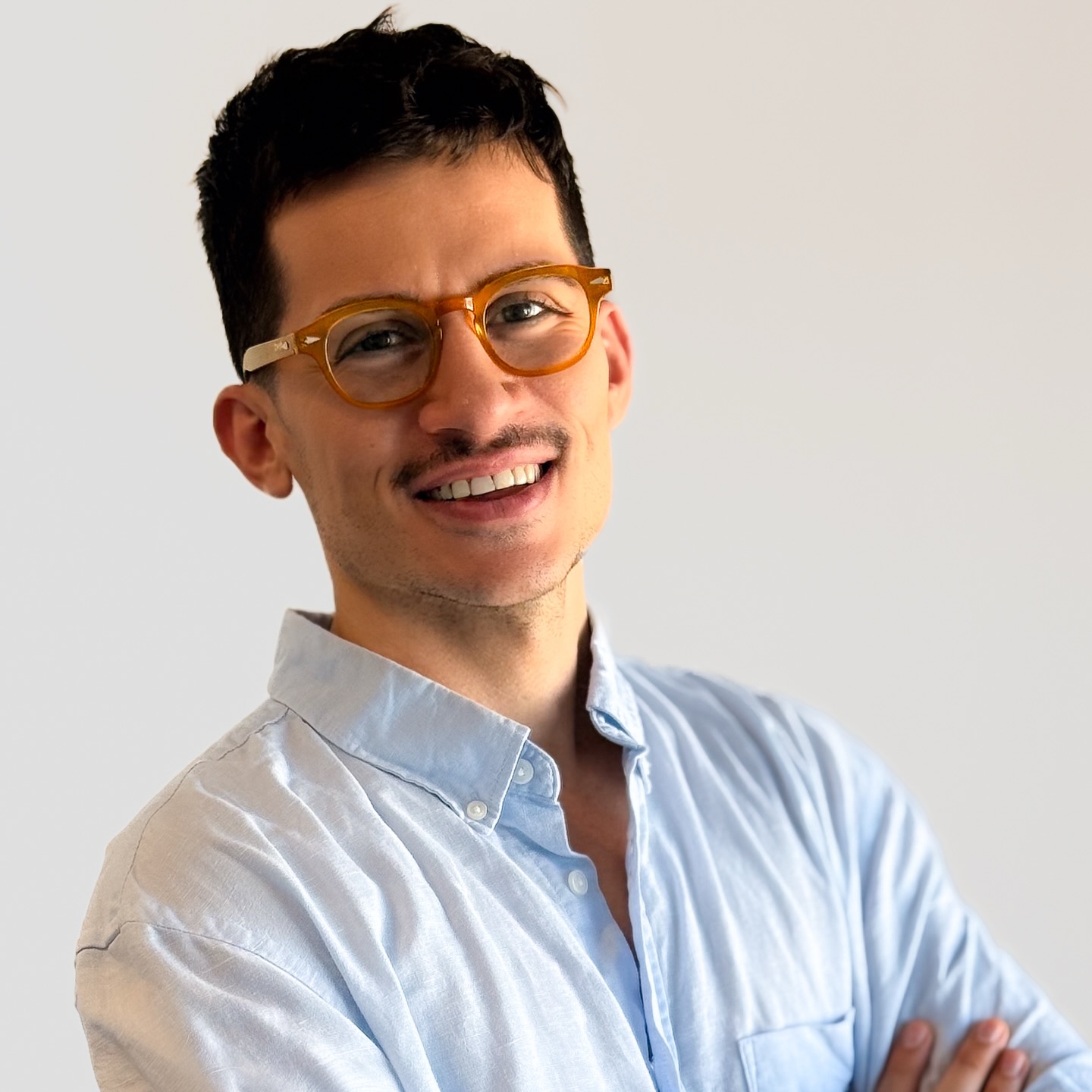 El Dr. Emilio Camargo, sonriendo, con anteojos y camisa celeste